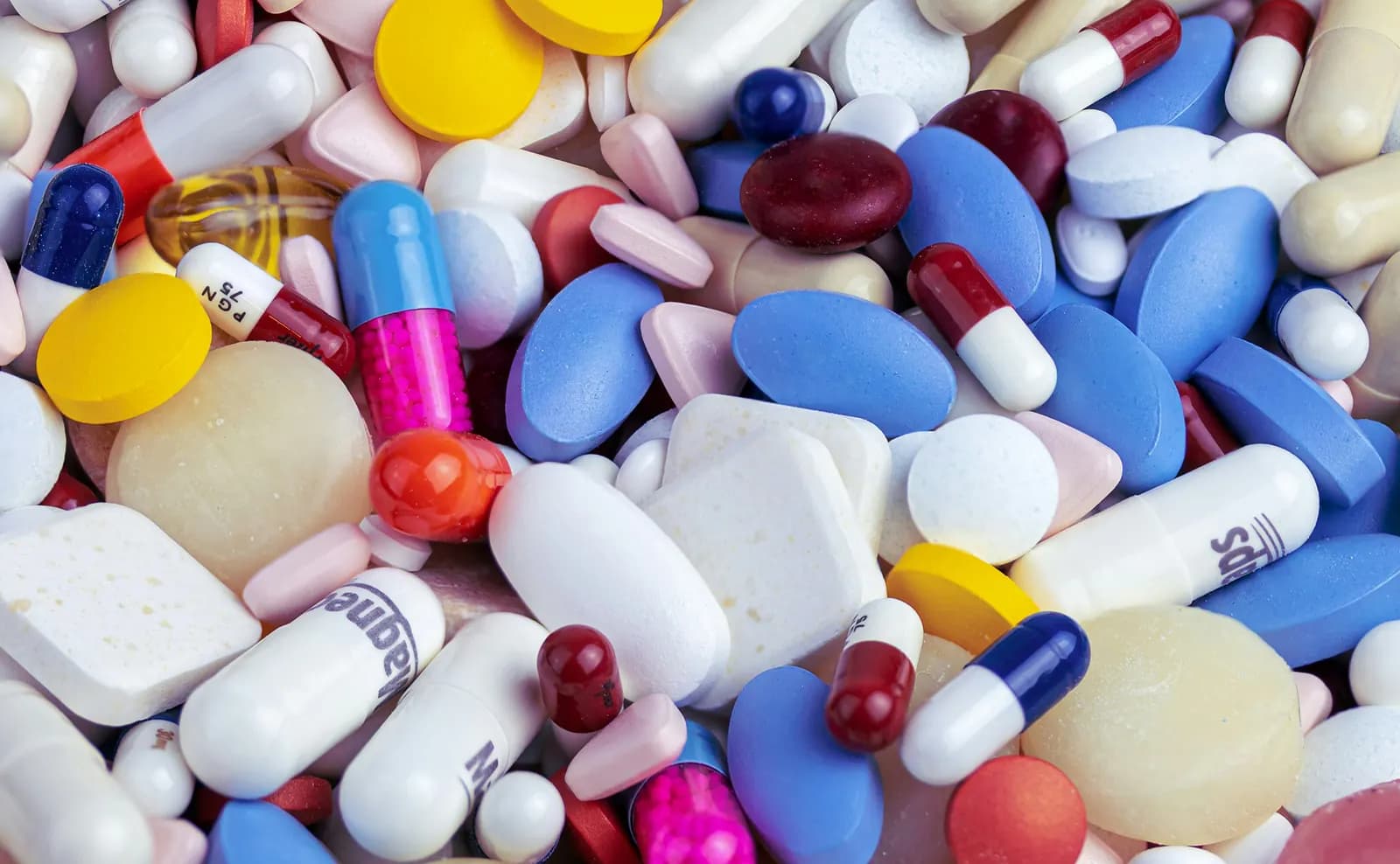 A close-up pile of colourful tablets and capsules